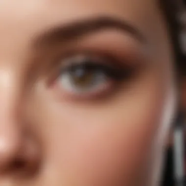 A user applying Maybelline mascara with a focused expression.