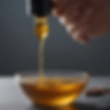 Close-up of a dropper dispensing organic oil into a small bowl