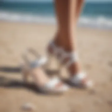 Elegant white summer sandals on a beach